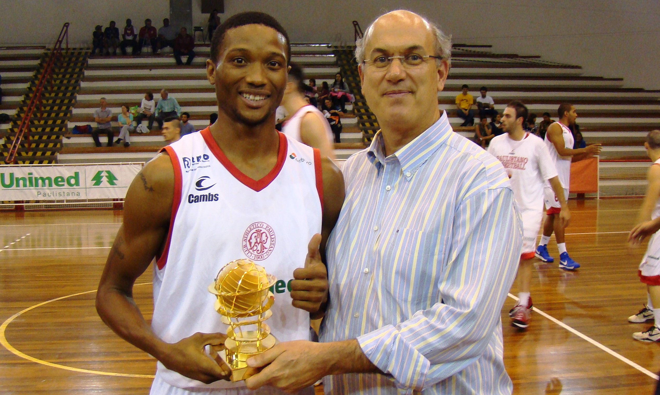 Holloway recebeu o troféu de cestinha das mãos do diretor de basquete do Paulistano, Silas Grassi (Divulgação)